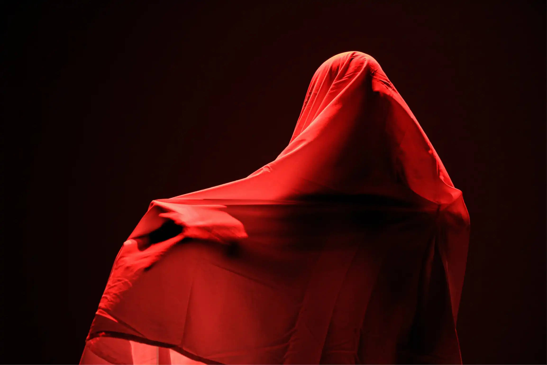 Human figure covered by red veil